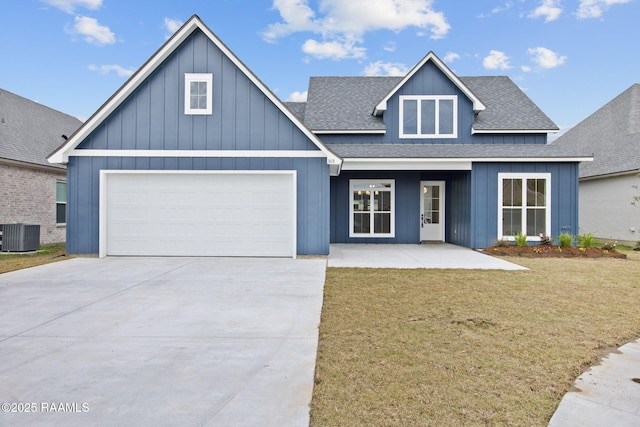 view of front of house featuring a front yard, a garage, and central AC unit