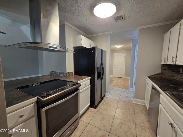 kitchen featuring light tile patterned floors, appliances with stainless steel finishes, white cabinetry, crown molding, and wall chimney exhaust hood