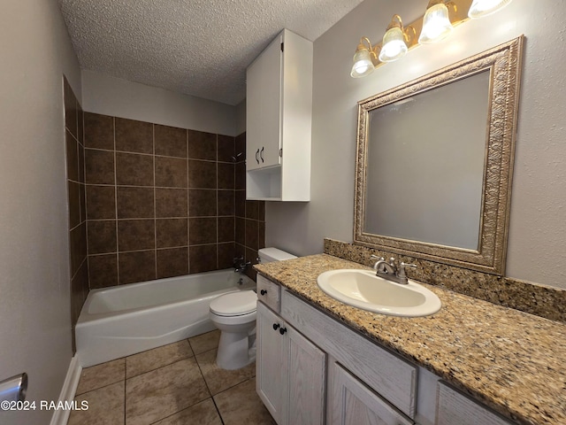 full bathroom with tile patterned floors, toilet, tiled shower / bath combo, vanity, and a textured ceiling