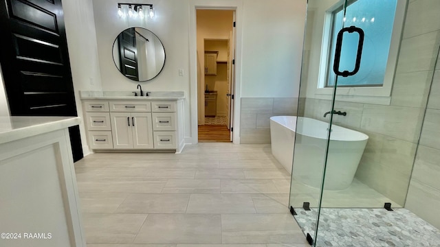 bathroom with tile patterned flooring, vanity, tile walls, and independent shower and bath