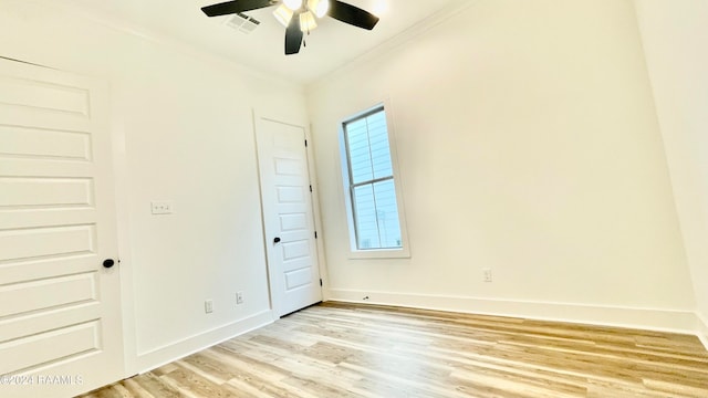 empty room with ceiling fan, ornamental molding, and light hardwood / wood-style flooring