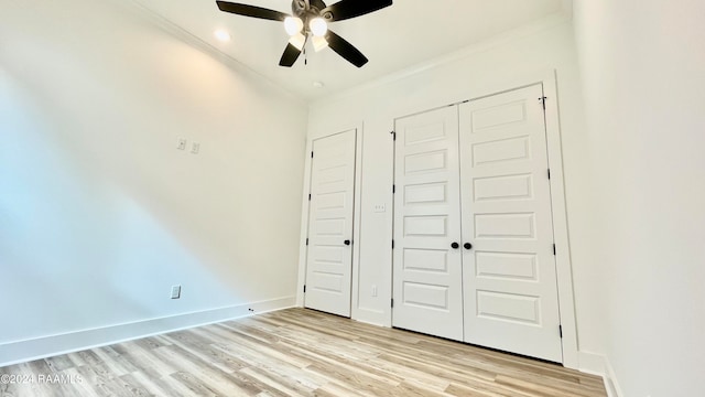 unfurnished bedroom with ceiling fan, a closet, ornamental molding, and light wood-type flooring