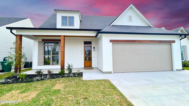 view of front facade featuring a lawn, a porch, and a garage