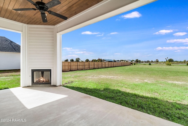 view of yard featuring ceiling fan, a fireplace, and a patio