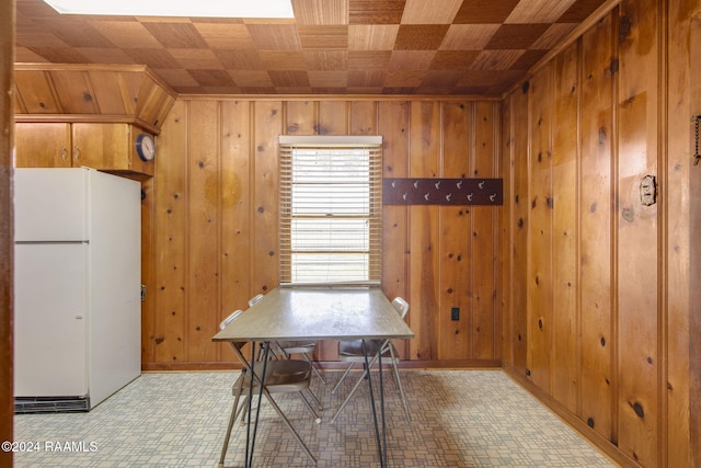 unfurnished dining area with wood ceiling and wooden walls