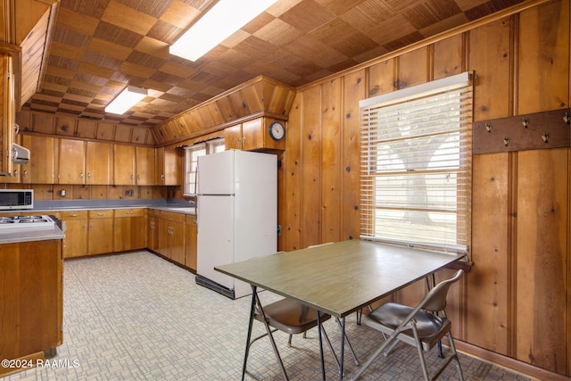 kitchen with wooden walls and white refrigerator