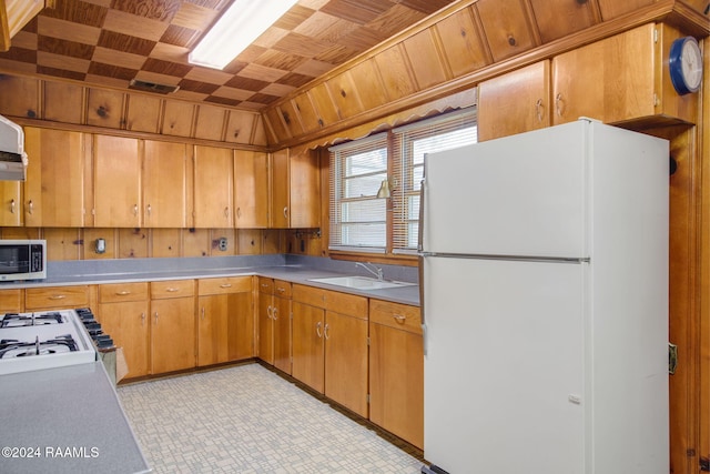 kitchen featuring white appliances, wooden ceiling, and sink