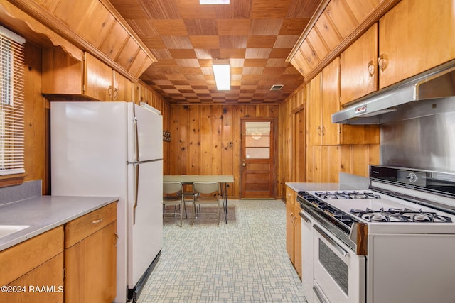 kitchen featuring white appliances and wooden walls