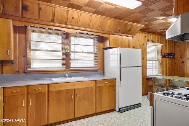 kitchen featuring white appliances, wood walls, sink, wooden ceiling, and extractor fan