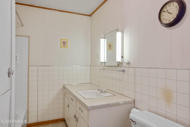 bathroom featuring tile walls, vanity, ornamental molding, and toilet