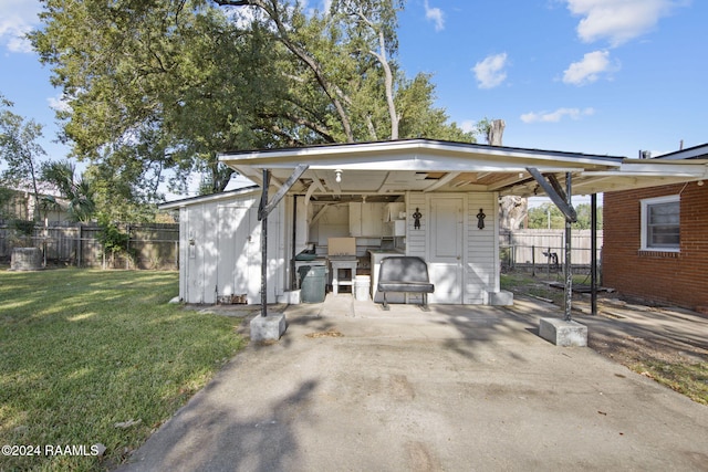 back of property featuring a patio area, a yard, and a storage unit