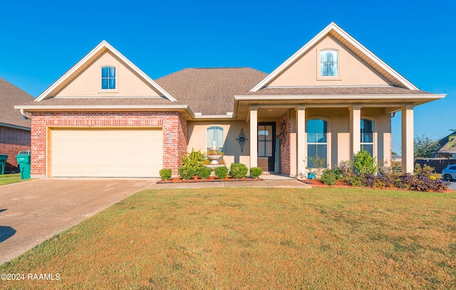 view of front of property featuring a front yard, a garage, and covered porch