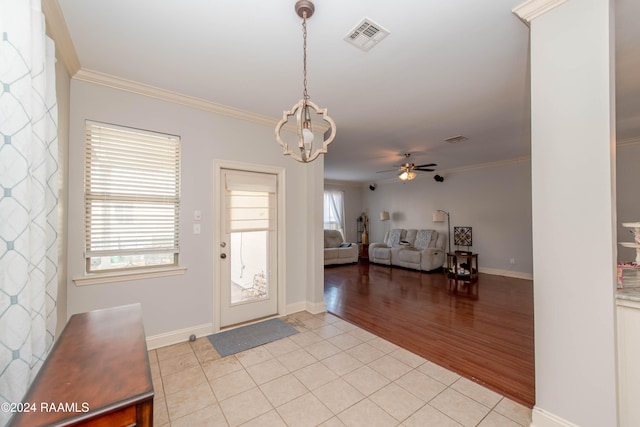 entryway featuring crown molding, light hardwood / wood-style flooring, and ceiling fan with notable chandelier