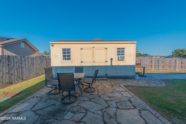 rear view of house with a patio, an outbuilding, and a lawn