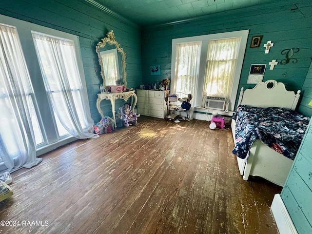 510 S Adams St, Welsh, LA 70591 - bedroom featuring hardwood / wood-style floors, multiple windows, wooden walls, and cooling unit