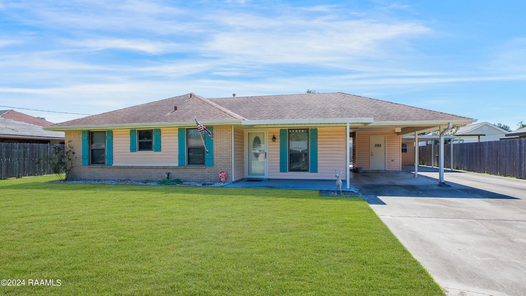 ranch-style home featuring covered porch, fence, a carport, concrete driveway, and a front lawn