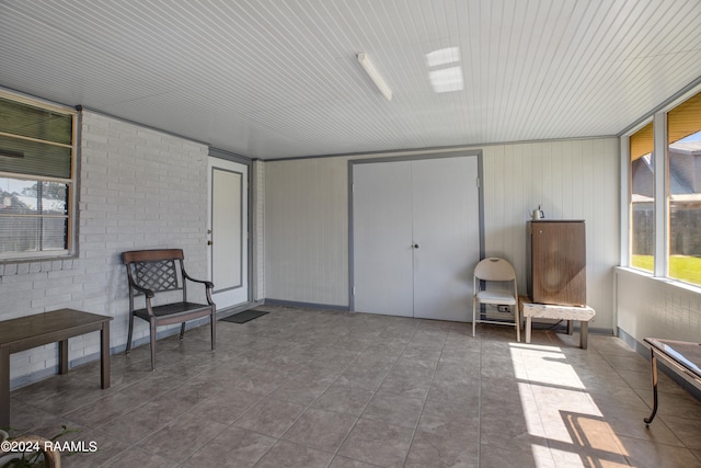 sitting room with brick wall and tile patterned floors