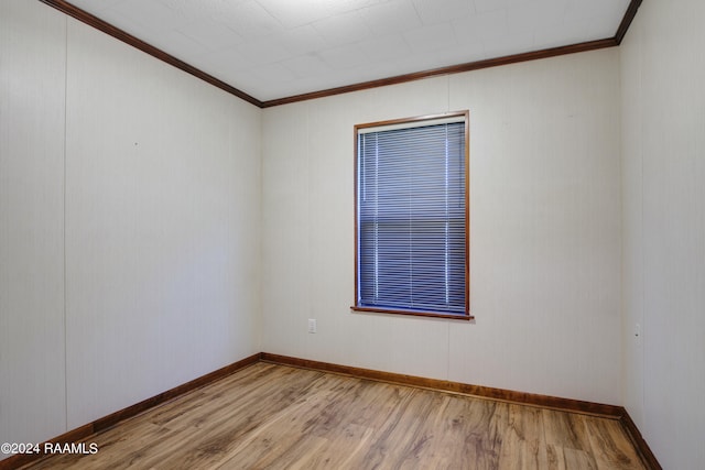 spare room with crown molding and light wood-type flooring