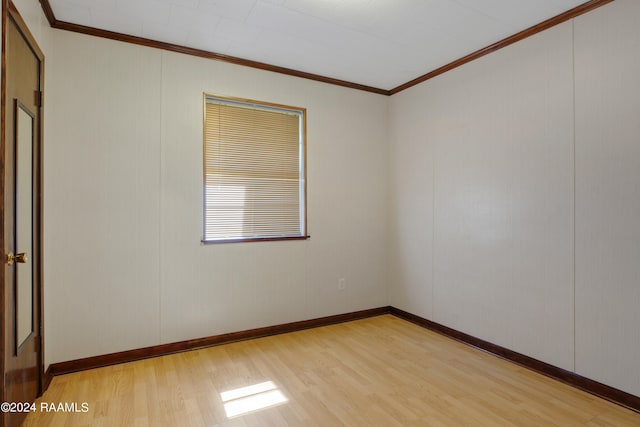 empty room featuring crown molding and light wood-type flooring