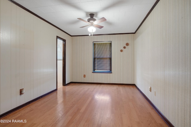 spare room with ceiling fan, crown molding, and light wood-type flooring