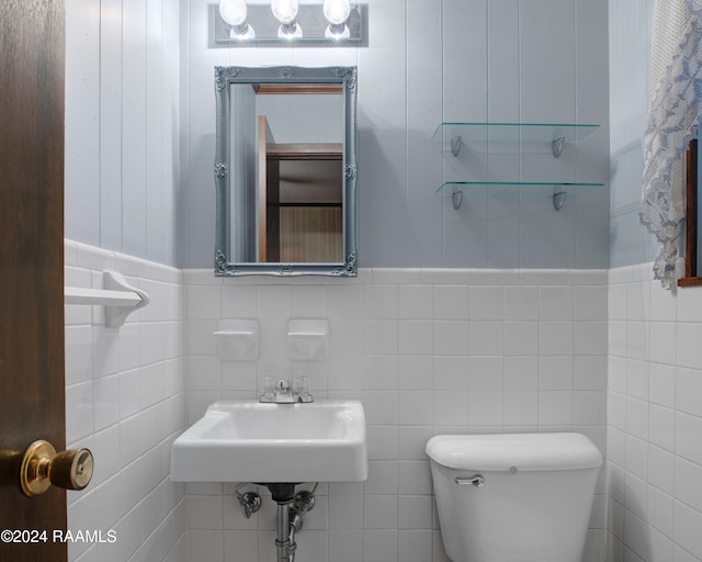 bathroom featuring tile walls, sink, and toilet