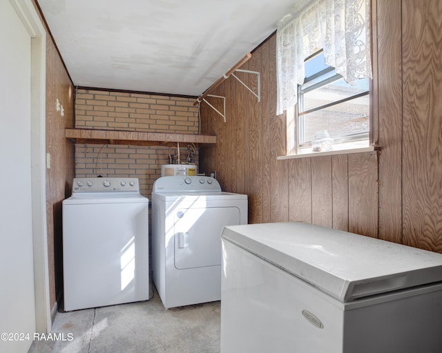 laundry room featuring independent washer and dryer and wood walls