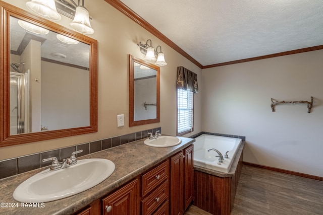 bathroom with hardwood / wood-style floors, a bathtub, a textured ceiling, vanity, and crown molding