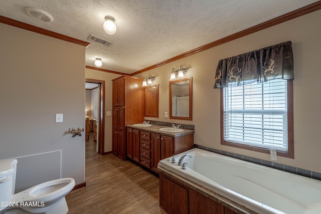 bathroom featuring wood-type flooring, vanity, a textured ceiling, a bathtub, and ornamental molding