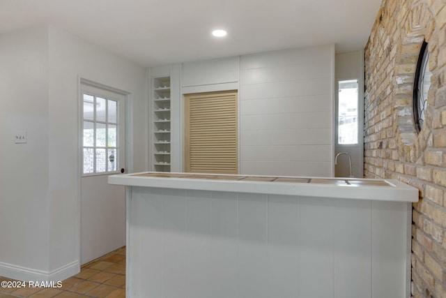 kitchen with kitchen peninsula, light tile patterned flooring, and a wealth of natural light