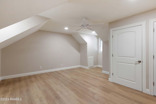 bonus room featuring light hardwood / wood-style floors, lofted ceiling with skylight, and ceiling fan