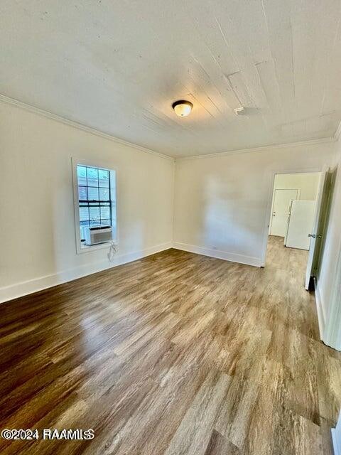 unfurnished room with crown molding, light hardwood / wood-style flooring, and cooling unit