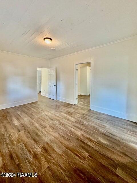 unfurnished room with crown molding and hardwood / wood-style floors