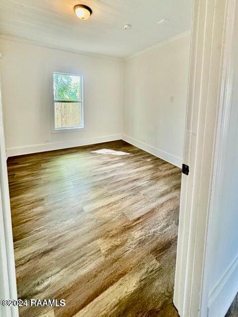 spare room featuring crown molding and hardwood / wood-style floors