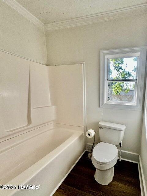 bathroom featuring toilet, crown molding, bathing tub / shower combination, and hardwood / wood-style floors