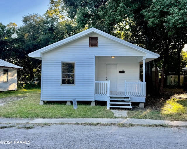 view of front of home with covered porch and a front lawn