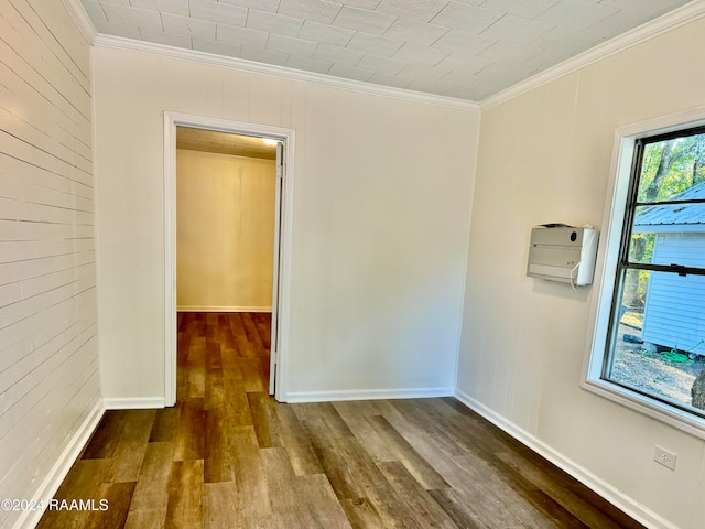 empty room featuring ornamental molding and dark hardwood / wood-style flooring