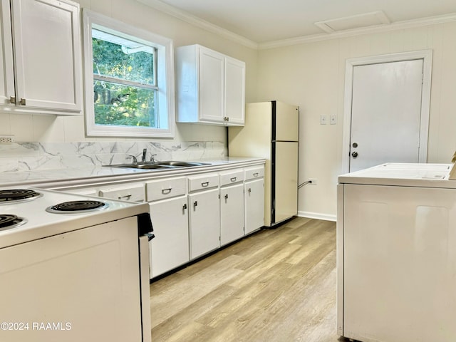 kitchen with washer / dryer, white appliances, sink, white cabinets, and crown molding