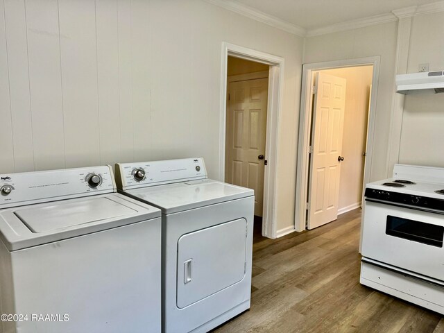 clothes washing area with crown molding and light hardwood / wood-style flooring