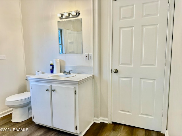 bathroom featuring vanity, hardwood / wood-style flooring, and toilet