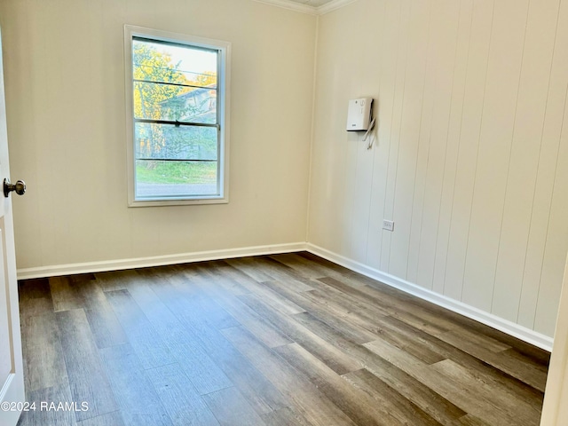 empty room with crown molding and hardwood / wood-style floors