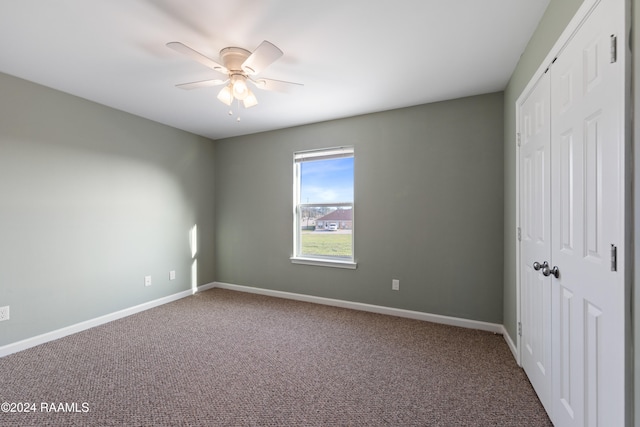 unfurnished bedroom featuring carpet floors, ceiling fan, and a closet