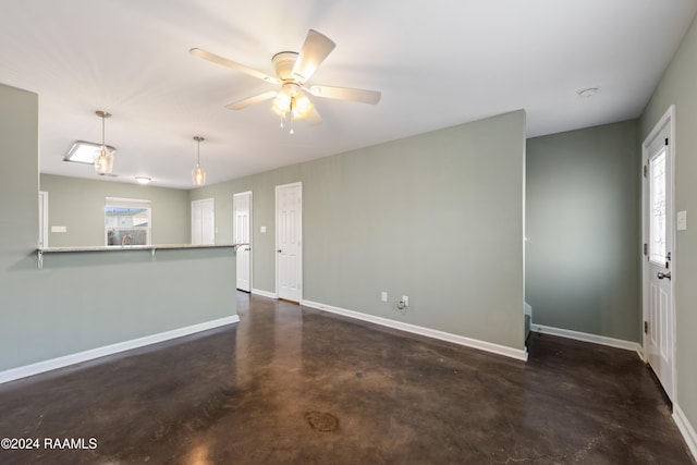 unfurnished living room featuring ceiling fan and a healthy amount of sunlight