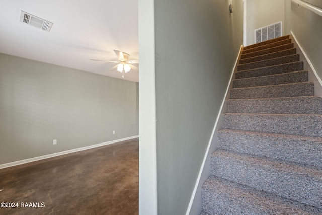 stairway with ceiling fan and carpet flooring