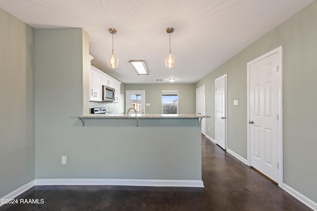 kitchen with pendant lighting, kitchen peninsula, white cabinetry, and a breakfast bar area