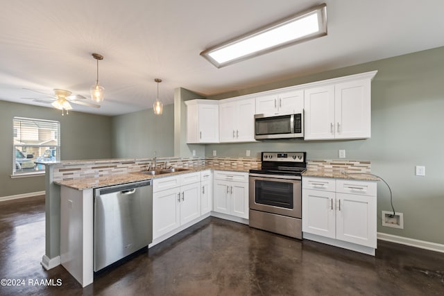 kitchen featuring light stone counters, pendant lighting, kitchen peninsula, white cabinetry, and appliances with stainless steel finishes