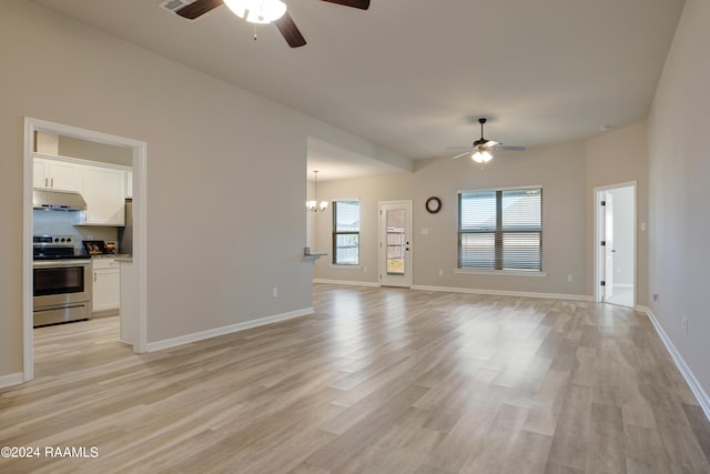 unfurnished living room with ceiling fan with notable chandelier and light hardwood / wood-style floors