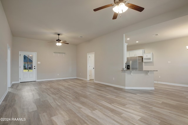 unfurnished living room with light wood-type flooring and ceiling fan