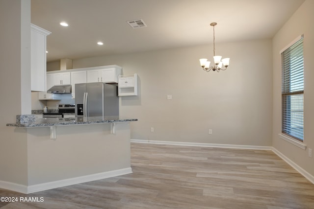 kitchen featuring white cabinets, appliances with stainless steel finishes, light hardwood / wood-style flooring, and hanging light fixtures