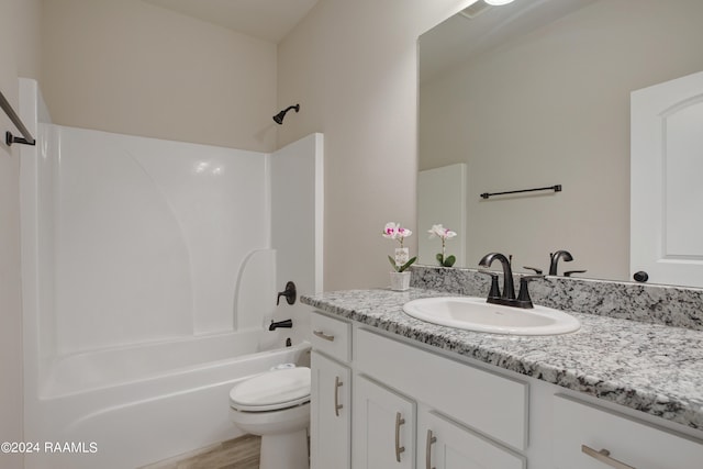 full bathroom with toilet, hardwood / wood-style floors, vanity, and  shower combination