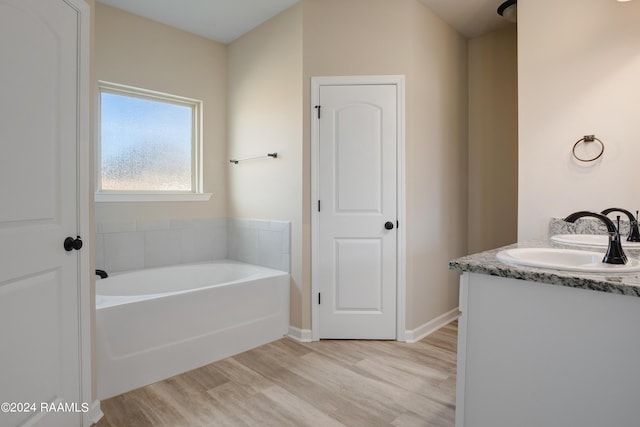 bathroom featuring vanity, a tub to relax in, and hardwood / wood-style floors